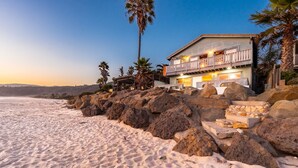 A beachfront property with a wooden deck, large rocks, and a view of the ocean. - Toes in the Sand! Amazing Location & Views* (Ventura)