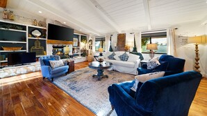 A spacious living room with a fireplace, a television, and a large window with curtains. - Perfect For Families, Near Wineries W/Private Pool (Temecula)