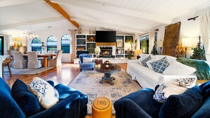 A spacious living room with a fireplace, a dining area, and a large window. - Perfect For Families, Near Wineries W/Private Pool (Temecula)