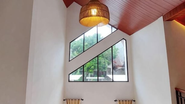 A room with a high ceiling, large windows, and a hanging light fixture. - Yustien Homestay Jogja 3 Bedroom - Entire House (Kasihan)