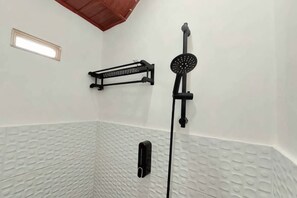 A shower area with a handheld showerhead, a towel rack, and a vent. - Yustien Homestay Jogja 3 Bedroom - Entire House (Kasihan)