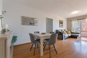 A modern living space with a dining table, chairs, a sofa, and a large mirror on the wall. - Brisas Del Mar Eddy: Mountain Views, Wi-Fi & Air Conditioning for Your Vacation (Candelaria)