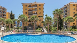 Una piscina rodeada de palmeras y edificios amarillos.