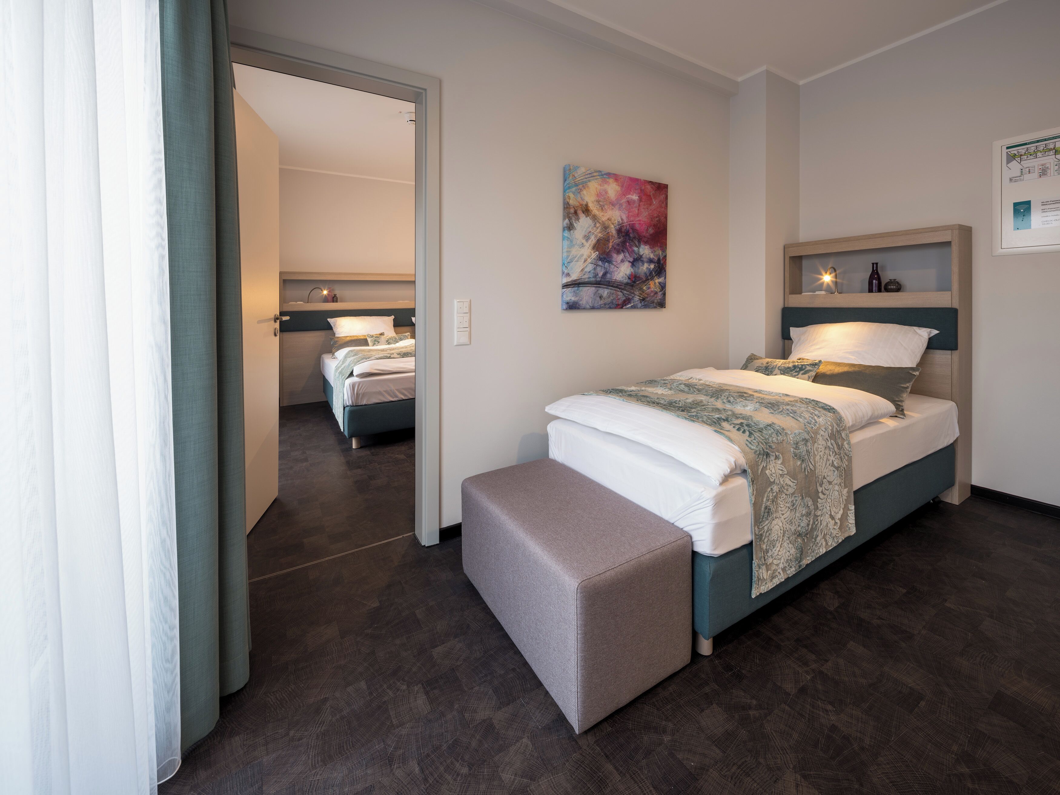 Una camera da letto moderna con un letto grande, una panca e un quadro appeso al muro.