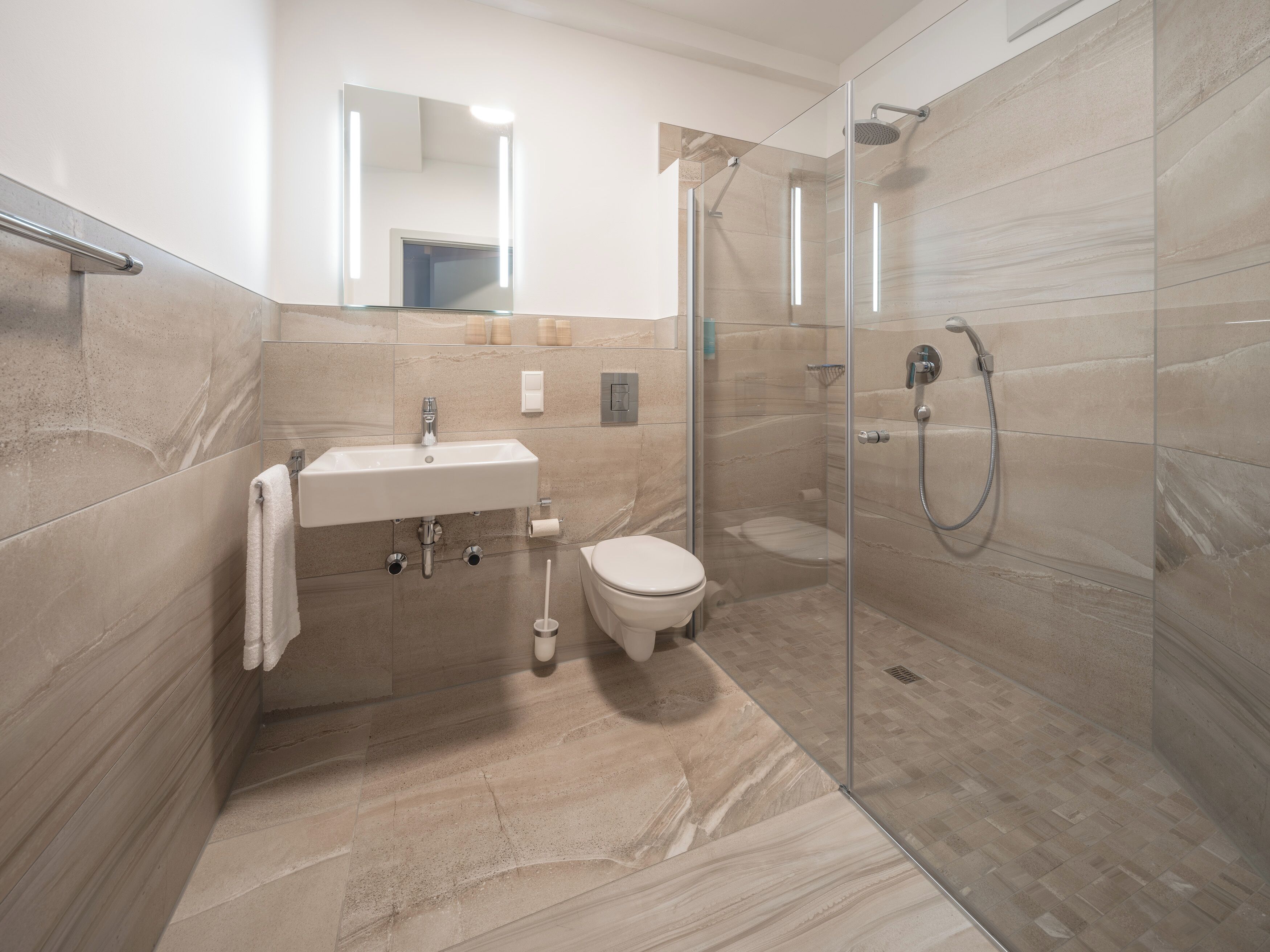 A modern bathroom with a glass-enclosed shower, a sink, and a toilet.