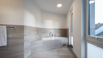 Deluxe tweepersoonskamer | Badkamer | Een haardroger, handdoeken, zeep, shampoo