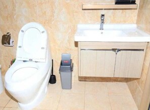 Ein Badezimmer mit Toilette, Waschbecken und Schrank.
