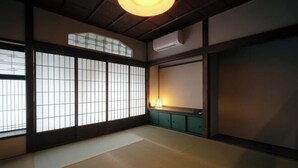 A traditional Japanese room with tatami flooring, sliding doors, and a ceiling fan. - SAKON UKON (Kanazawa)