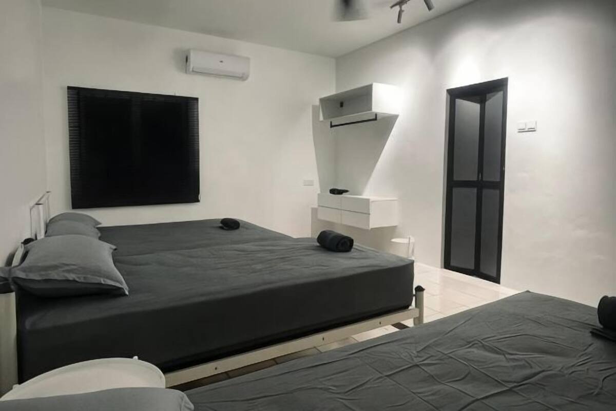A bedroom with a bed, a bedside table, a mirror, and a wardrobe.