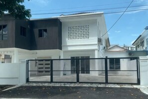 A modern two-story house with a gated driveway, a garage, and a large window on the upper floor. - 39 Haus (Bukit Mertajam)