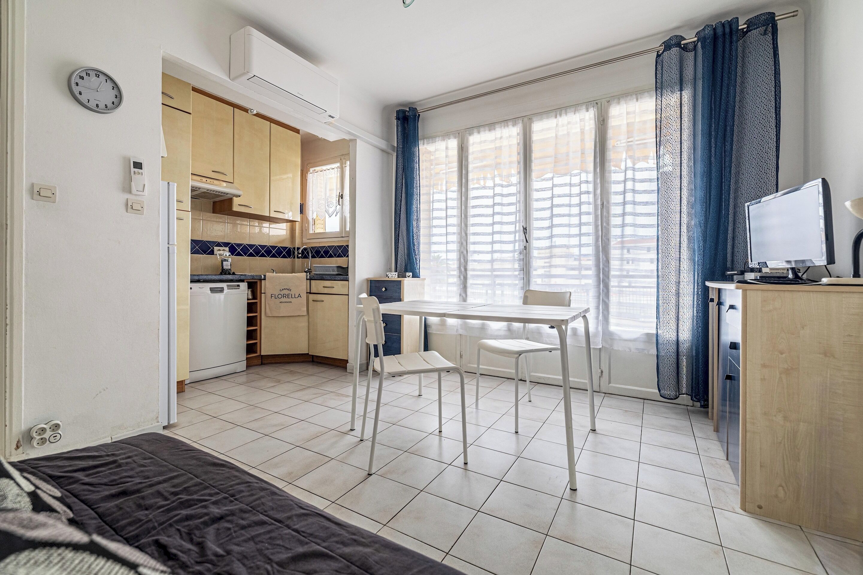 A compact living space with a kitchenette, a dining area, and a bed.