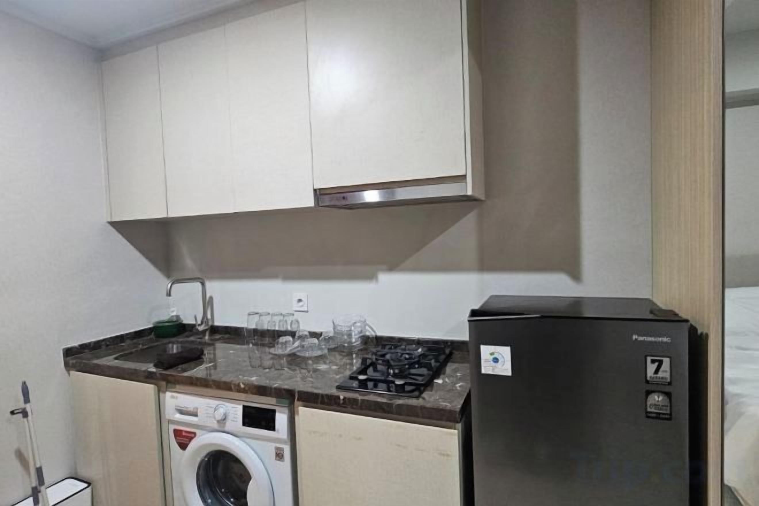 A compact kitchen with a washing machine, a refrigerator, and a stove.