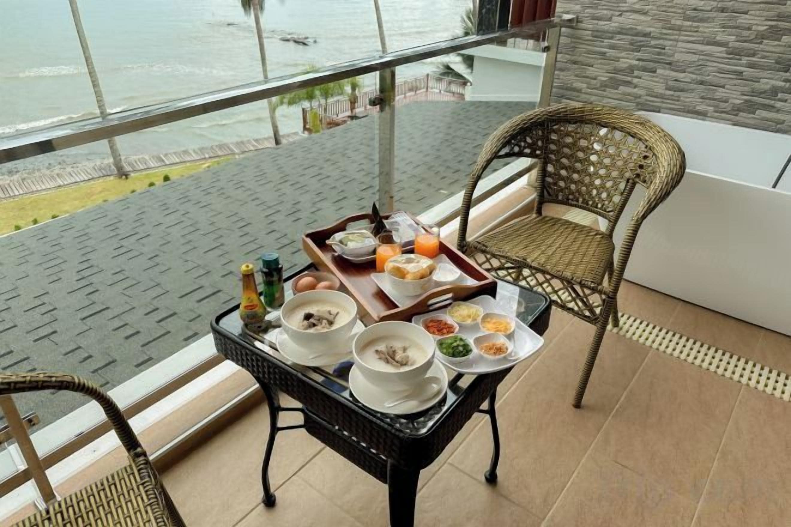 Varanda com mesa posta para o café da manhã, com vista para um corpo d'água.