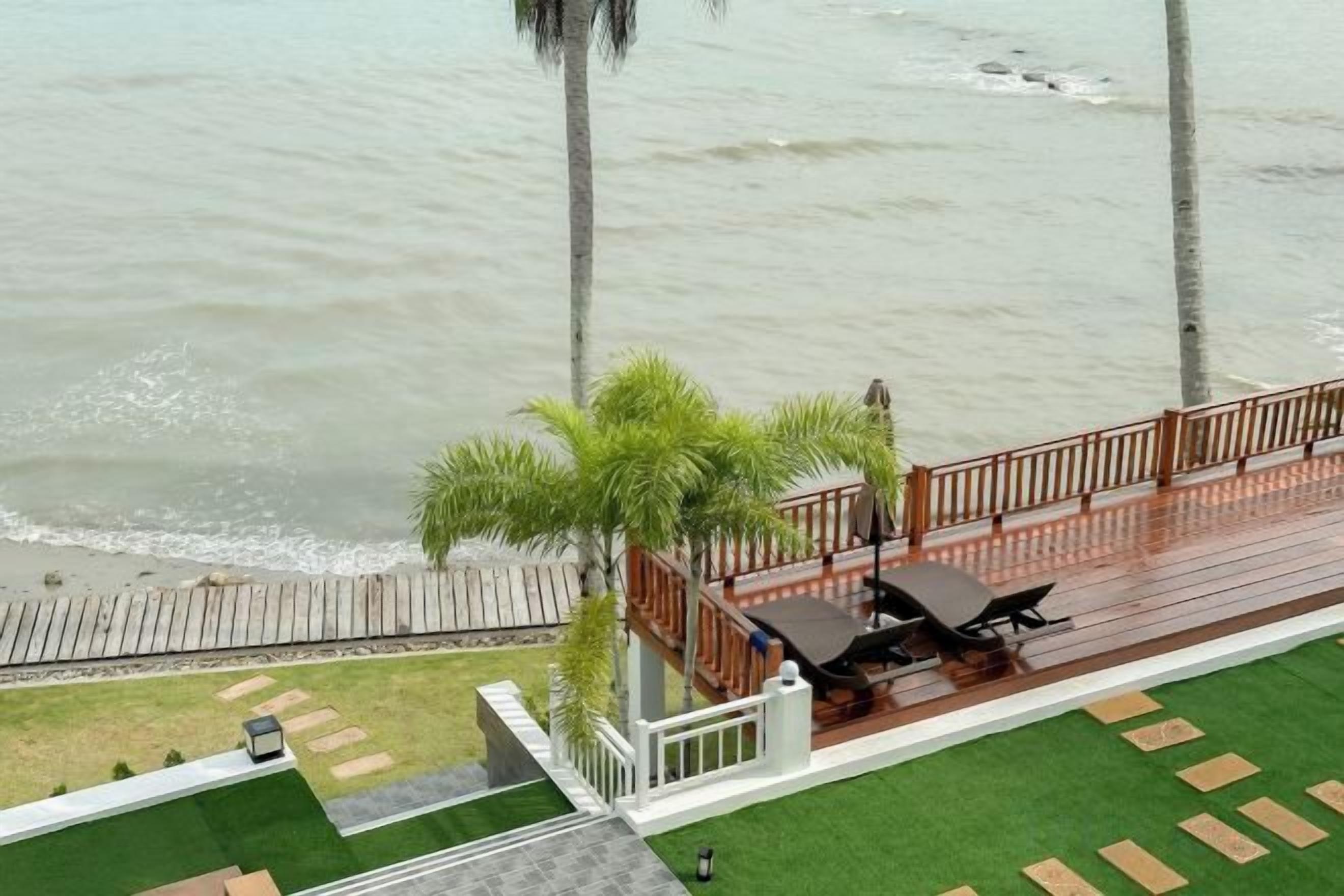 Een terras met uitzicht op zee, een klein tuinperkje en een zithoek.