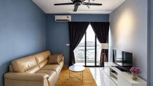 Ein modernes Wohnzimmer mit einer Couch, einem Flachbildfernseher, einem Couchtisch und einem Deckenventilator.