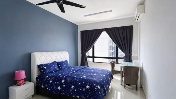 A bedroom with a bed, a desk, a chair, a ceiling fan, and a window with curtains.