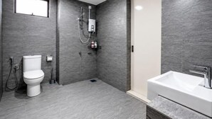 A modern bathroom with a toilet, shower, and sink.