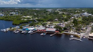 An aerial view of a marina with boats docked, a large building labeled "HICKORY," and surrounding greenery.
