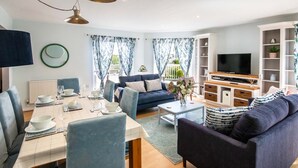 A modern living room with a dining area, a sofa, a TV, and a bookshelf. - Windrush Lake 20, Summit Lodge (P) - Lakeside Lodge, On-site Activites, Sleeps 7 (South Cerney)