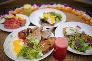 A table with various breakfast dishes including eggs, toast, and salads. - Ubud Jungle Stay - Mahari by WAHM (Bali)