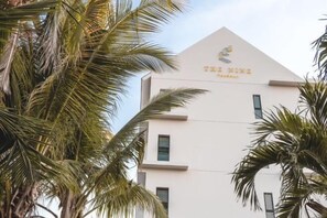 A building with a modern architectural design, featuring a prominent logo at the top. - The Nine Thasala (Chiang Mai)