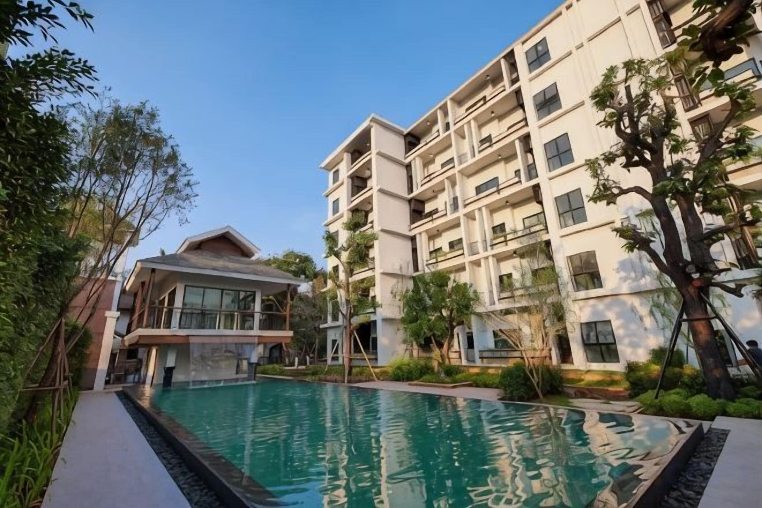Une piscine entourée d’immeubles résidentiels à plusieurs étages, dotés de balcons.