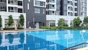 Un moderno edificio residenziale con piscina, balconi e aree verdi.