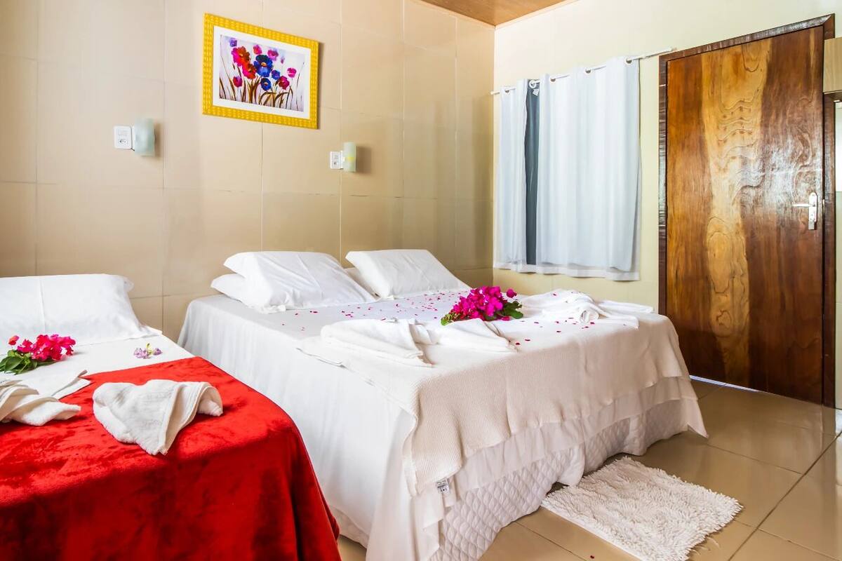 Een kamer met twee bedden, een houten deur en een raam met gordijnen.