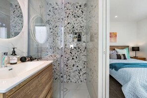 Une salle de bain moderne avec une douche en verre, un meuble-lavabo en bois et un grand miroir.