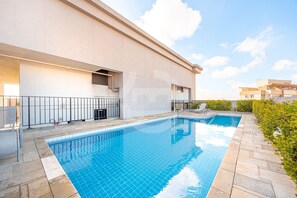 A modern building with a swimming pool, a covered area, and a clear sky. - Apartment with 1 parking space | UN1107 (Osasco)