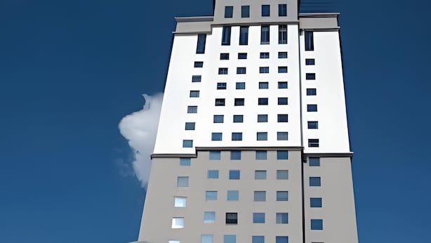 A modern building with a glass entrance and a sign that reads "HOTEL". - Apartment with 1 parking space | UN1105 (Osasco)
