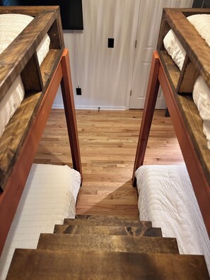 Una escalera de madera que lleva a una habitación con literas.
