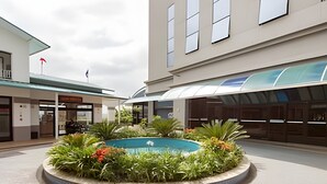 A courtyard with a central pool surrounded by greenery and a tiled floor. - Apartment with 1 parking space - UN1209 (Osasco)