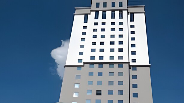 A modern building with a glass entrance and a sign that reads "HOTEL". - Apartment with 1 parking space | UN1103 (Osasco)