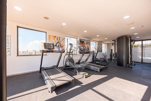 A gym with treadmills, stationary bikes, and a weight machine.