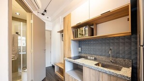 A modern kitchen with wooden cabinetry, a granite countertop, and a built-in microwave.