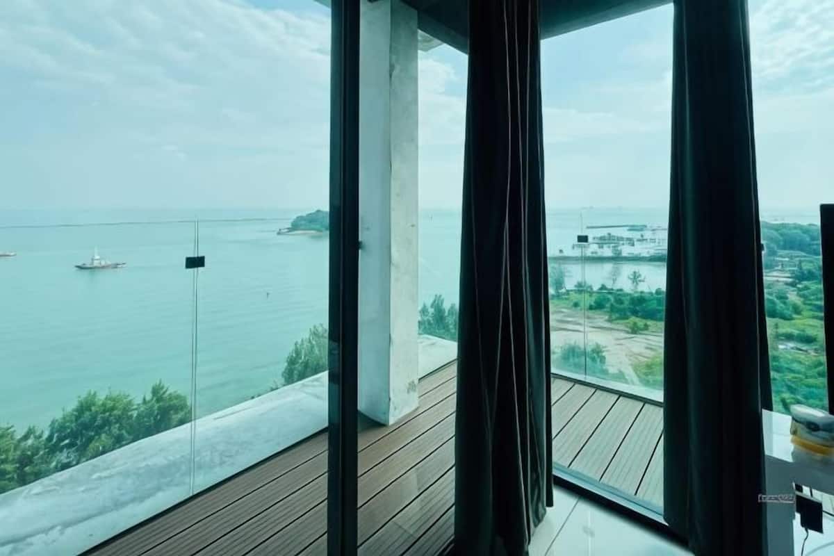 A view from a balcony with a clear sky, a body of water, and distant land.