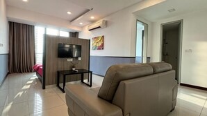 Un salon moderne avec un canapé, un téléviseur et une petite table.