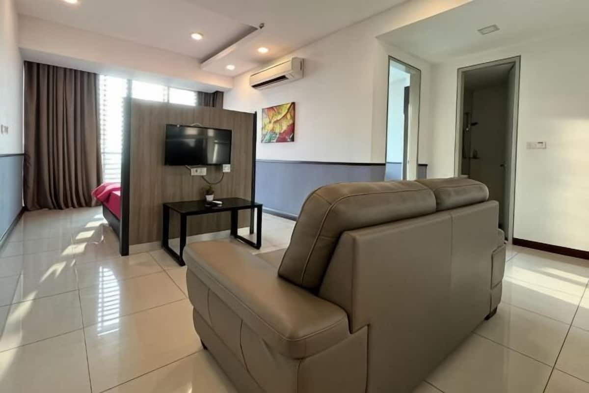 A modern living room with a sofa, a TV, and a small table.