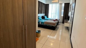 Une chambre d’hôtel équipée d’un lit, d’une armoire, d’un miroir et d’une poubelle.