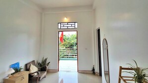 A hallway with a wooden bench, a small table with a lamp, and a potted plant. - Immersive Homestay NinhBinh  (Dai Hoang)