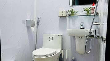 Un baño con inodoro, bidé y lavabo.