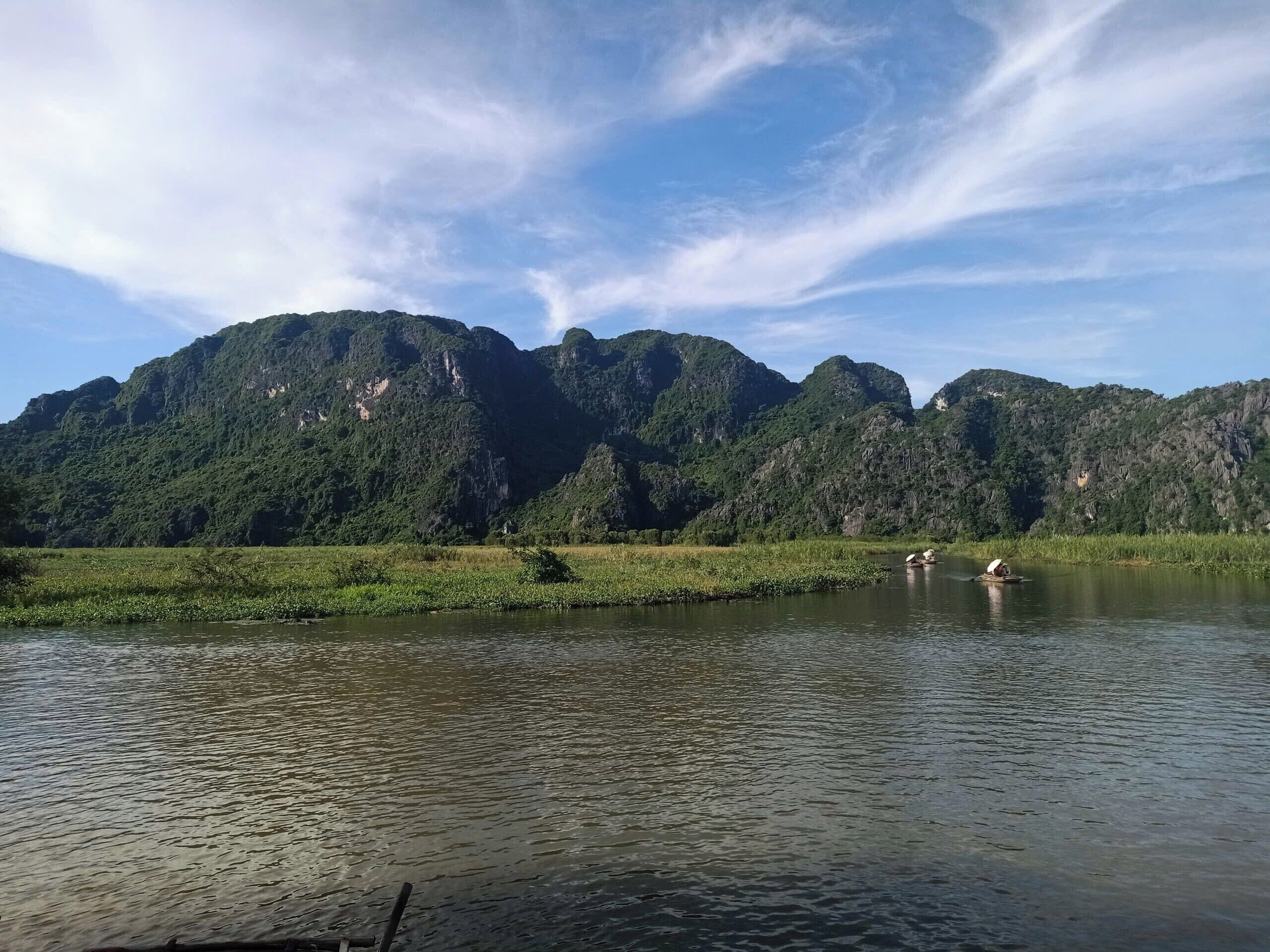A calm lake with mountains in the background and a clear sky.