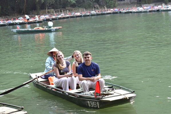A small boat with three people on it, floating on a body of water.