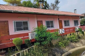 A pink building with barred windows, a wooden door, and a red roof. - Khuang Na Farmview (Mae Chaem)