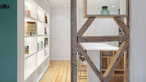 Un intérieur moderne avec des étagères blanches, un escalier en bois et une table blanche.
