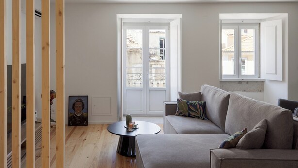 Un salon avec un canapé, une table basse ronde et un tableau accroché au mur.