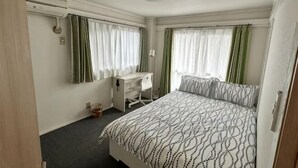 Una habitación de hotel con cama, escritorio y silla.