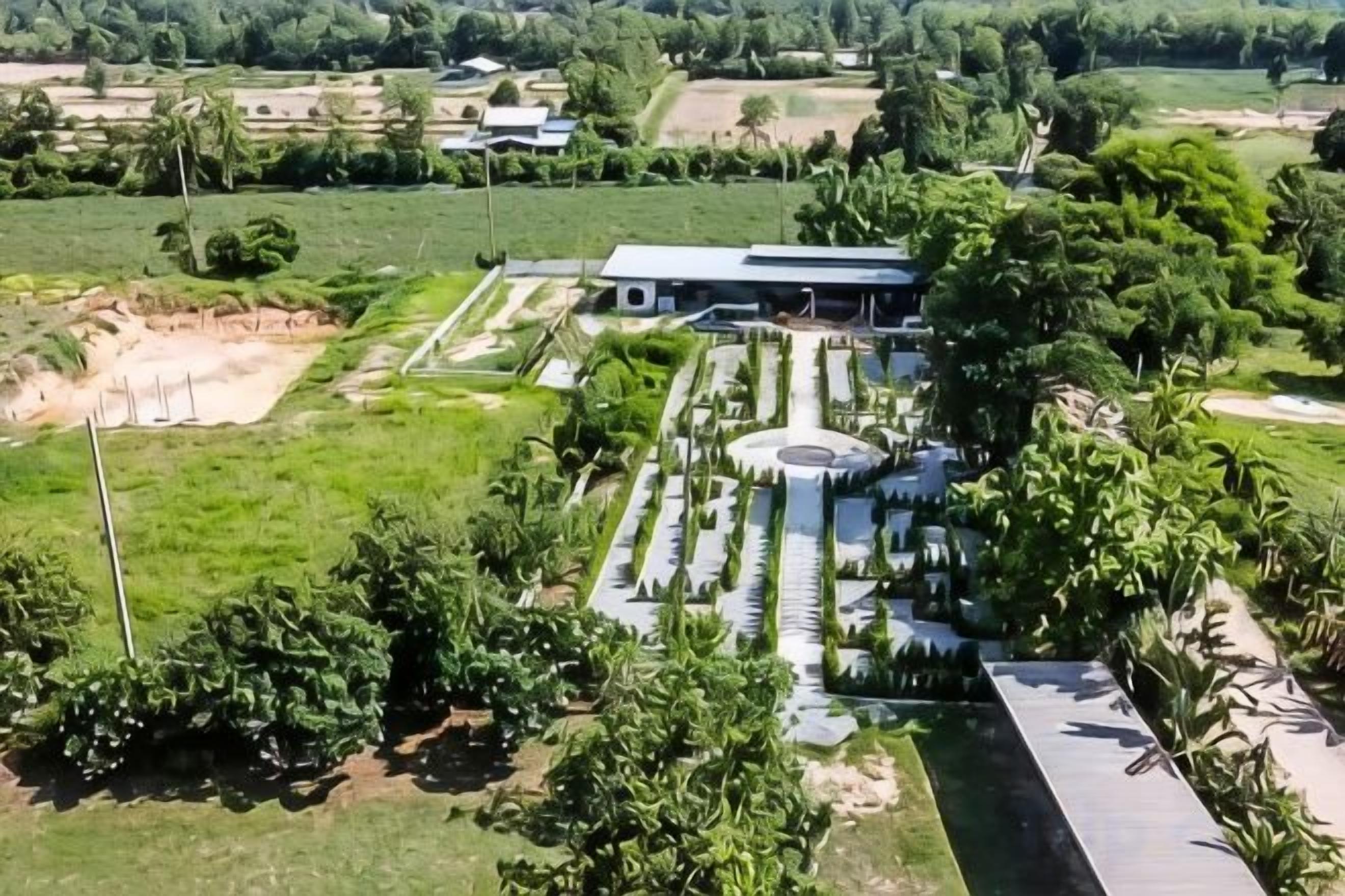A large building with a circular central courtyard surrounded by a symmetrical garden layout.