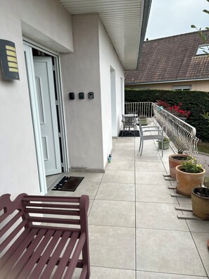 A covered outdoor area with a bench, potted plants, and a railing. - Large, comfortable room, parking spaces, pets welcome, bicycle garage (Étaples)